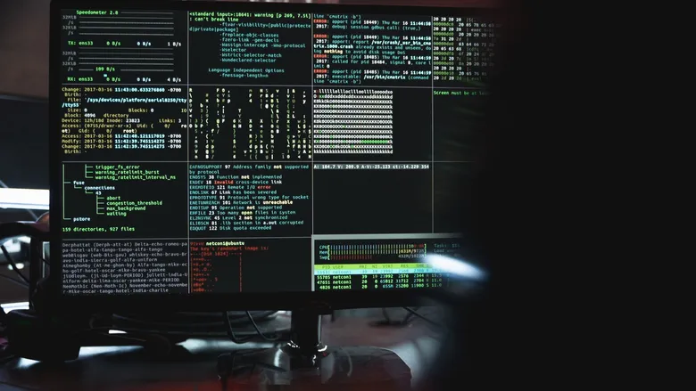Close-up of a computer monitor displaying lines of code and system data