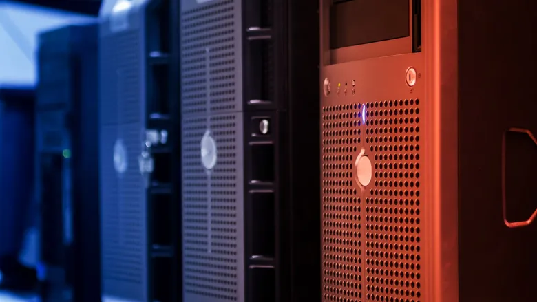 Row of tower servers in a data center lit with blue and red lights